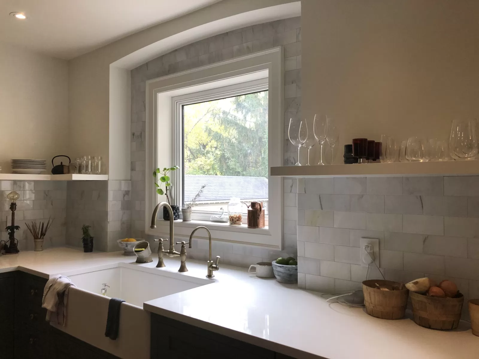 Light rectangular kitchen backsplash tile around a window and open shelves