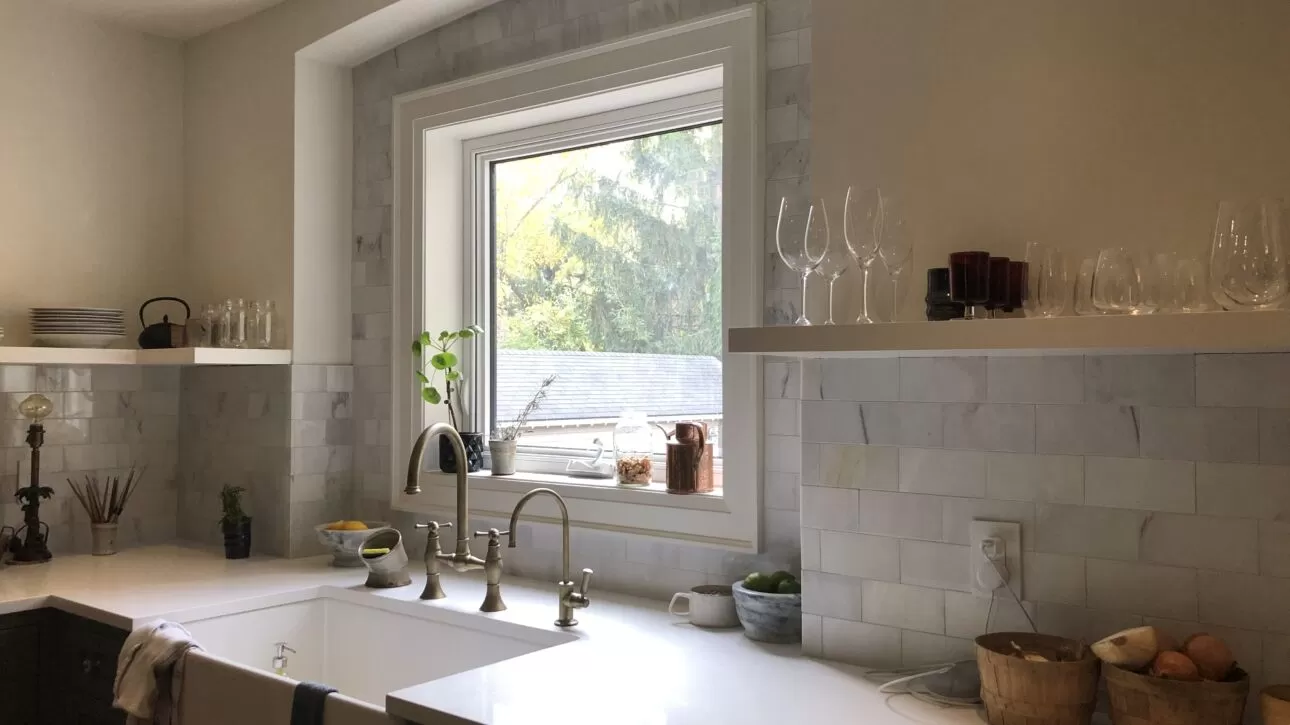 Light rectangular kitchen backsplash tile around a window and open shelves