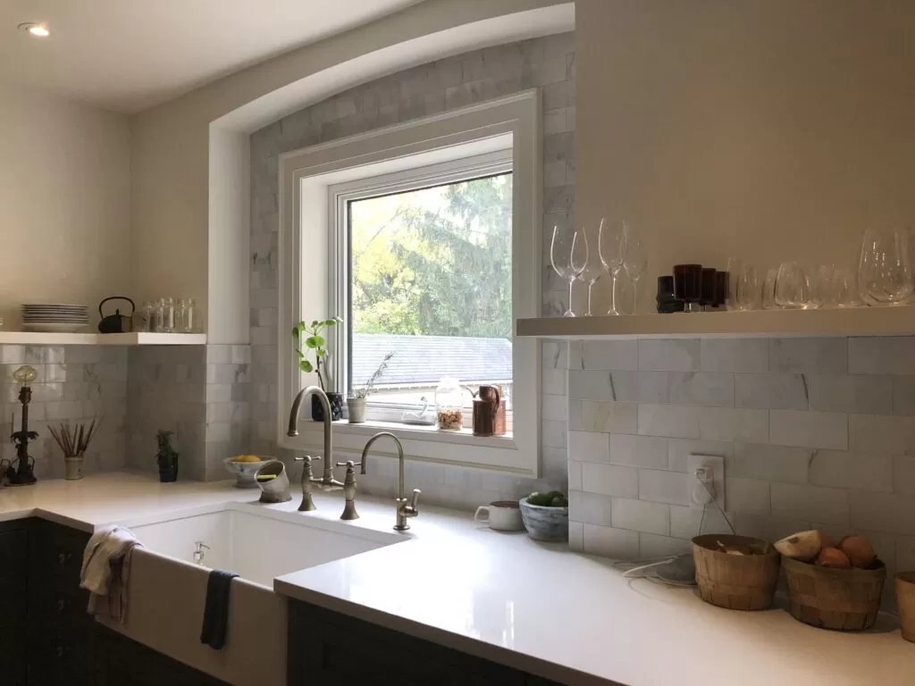 Light rectangular kitchen backsplash tile around a window and open shelves