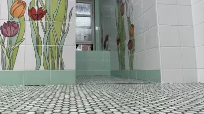 Floral bathroom wall tiles with green accents and a hexagon mosaic floor