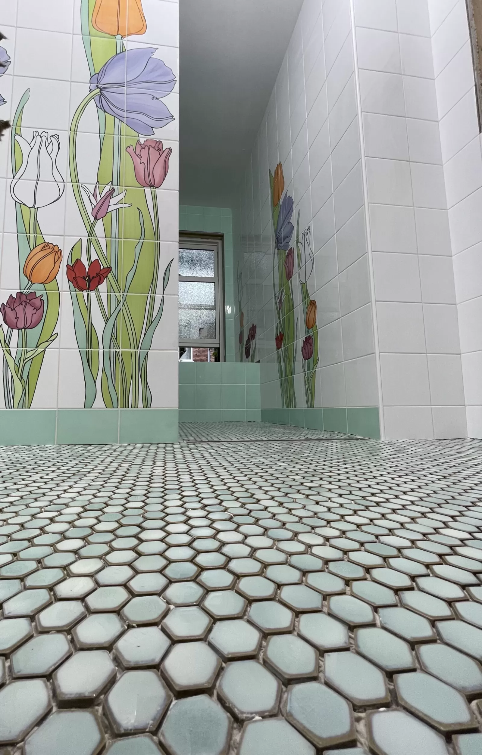 Floral bathroom wall tile, green accents and small hexagon mosaic floor
